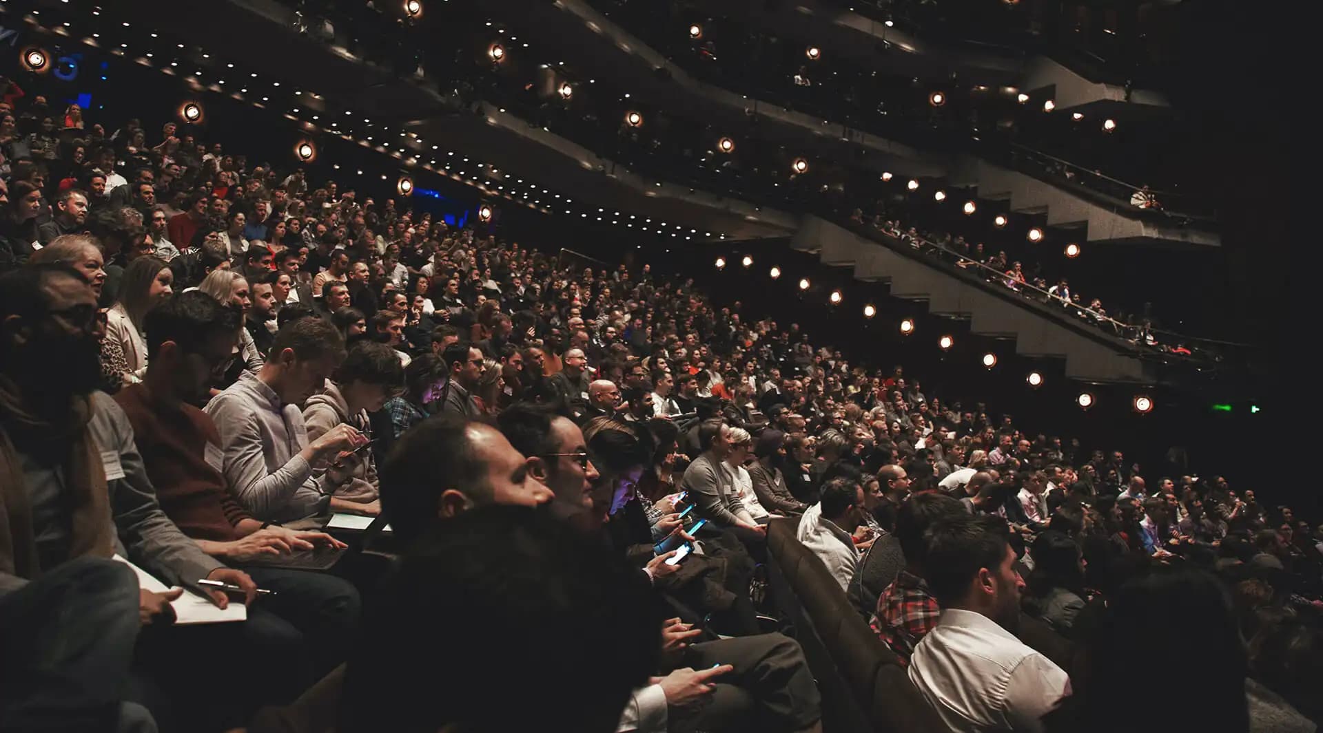 Audience seated inside a conference auditorium